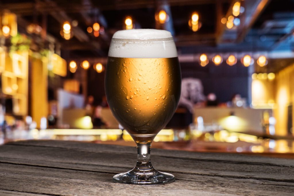 selective focus of glass of beer standing on table in pub selective focus of glass of beer standing on table in pub